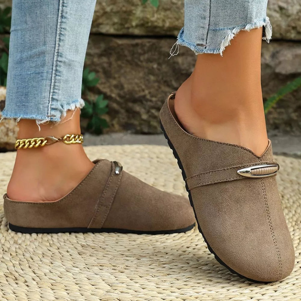 Brown slip-on flats with round toe and decorative metal accent.