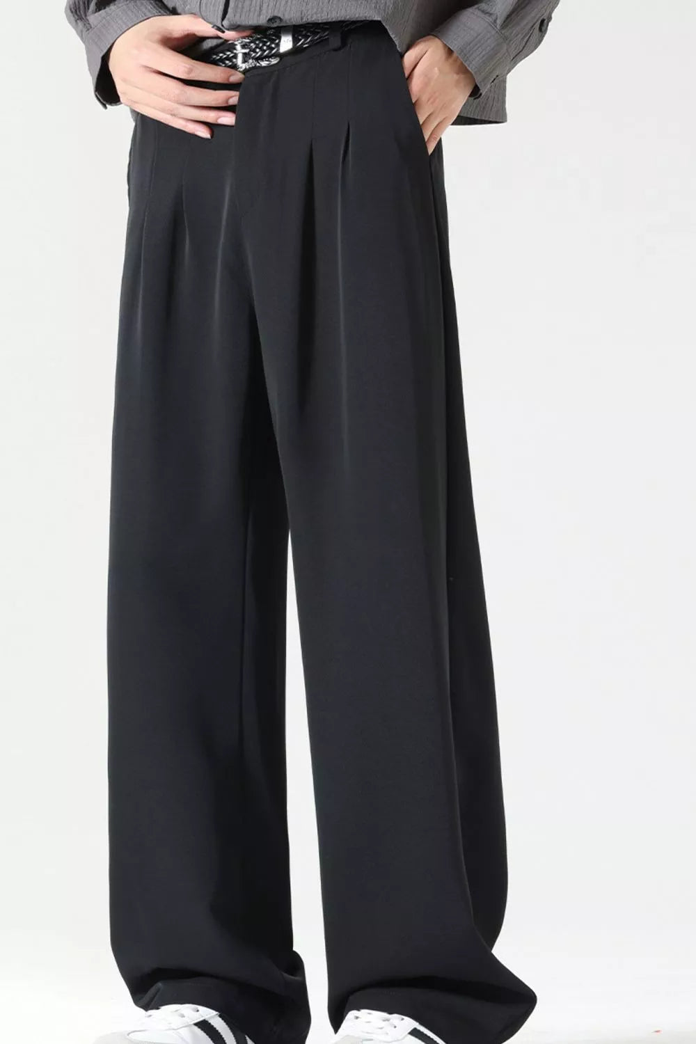 Men's black wide leg dress pants with pleats and a belt.