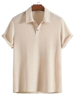 Beige textured polo shirt with a waffle knit, button placket, and cuffed rolled sleeves.