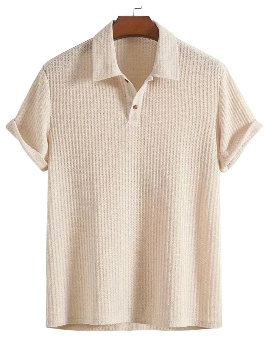 Beige textured polo shirt with a waffle knit, button placket, and cuffed rolled sleeves.