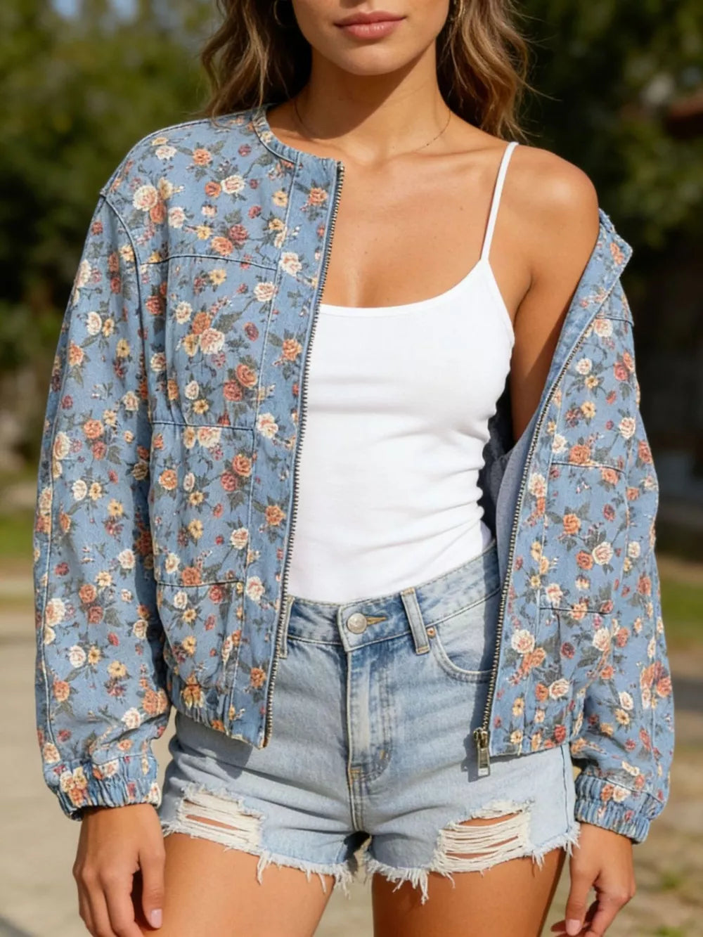 Floral-embellished denim bomber jacket with zip-up front and elastic cuffs.