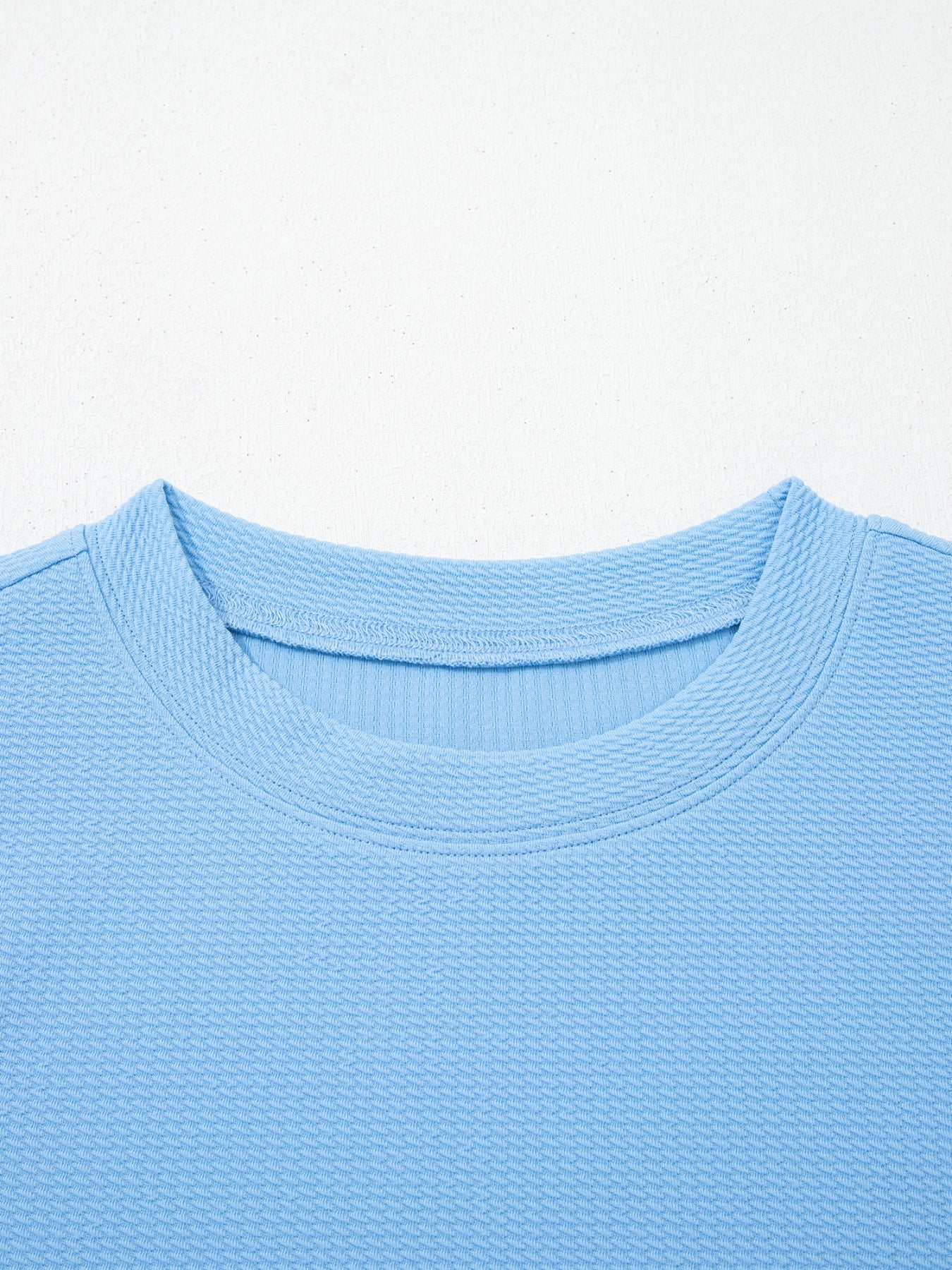 Light blue textured blouse with crew neck and bubble sleeves