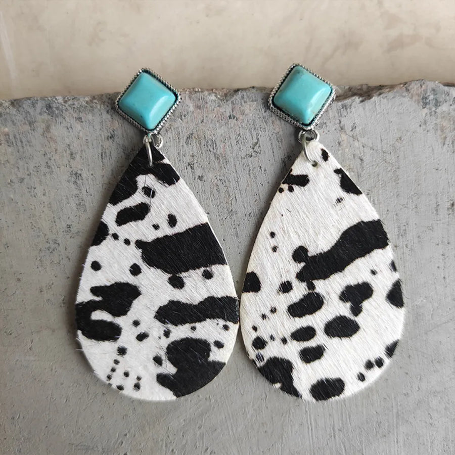 Teardrop earrings with cow print texture and turquoise square tops.