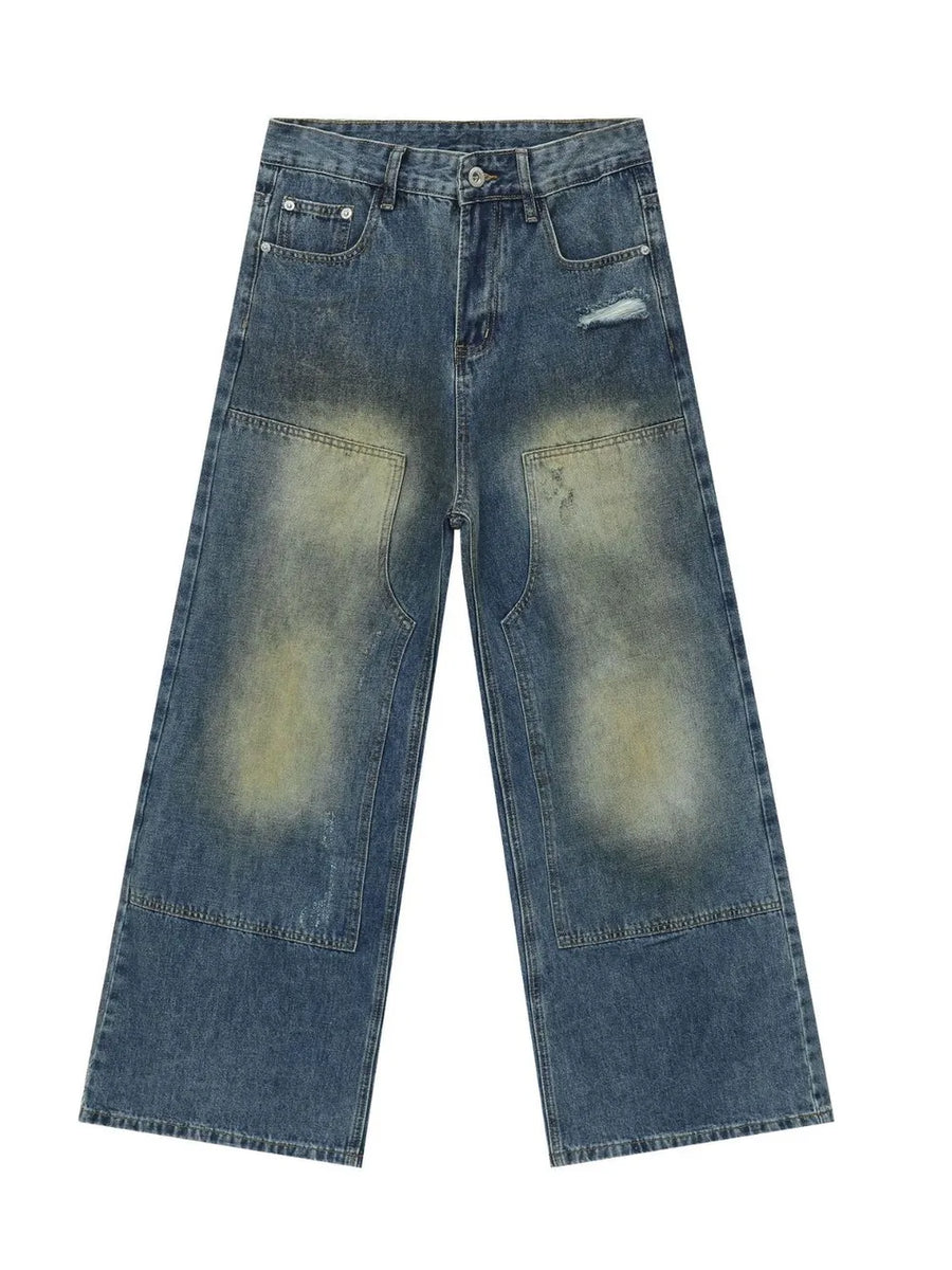 Faded patchwork denim palazzo trousers in medium wash with distressed details and wide legs.