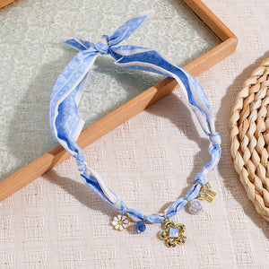 white necklace featuring charms and abstract