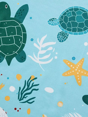 Light blue fabric with a cartoon sea turtle and starfish pattern.