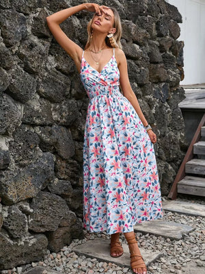 Floral print midi dress with smocked waist, V-neck, and spaghetti straps.