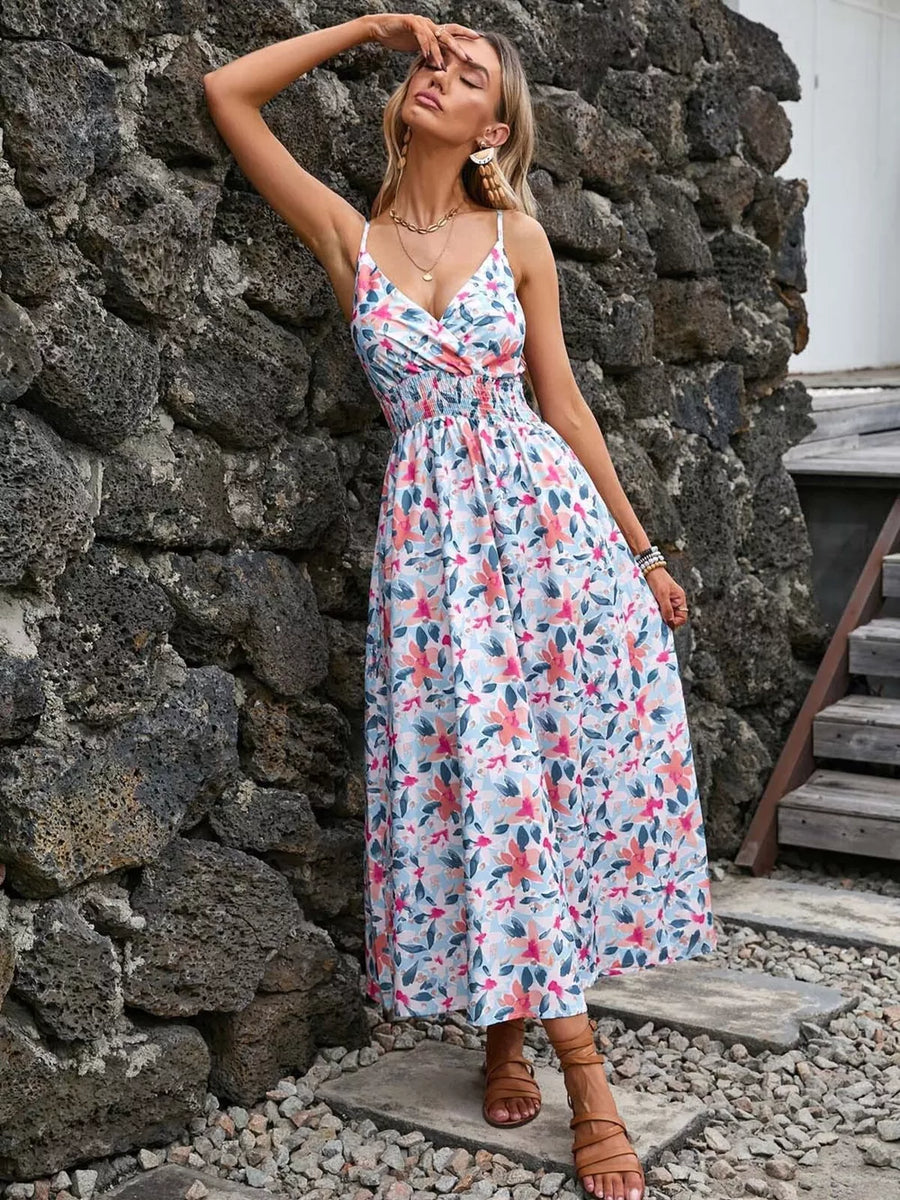 Floral print midi dress with smocked waist, V-neck, and spaghetti straps.
