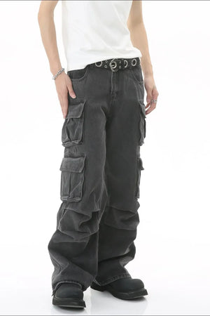Baggy dark wash denim cargo pants with multiple pleated pockets and a silver grommet belt.