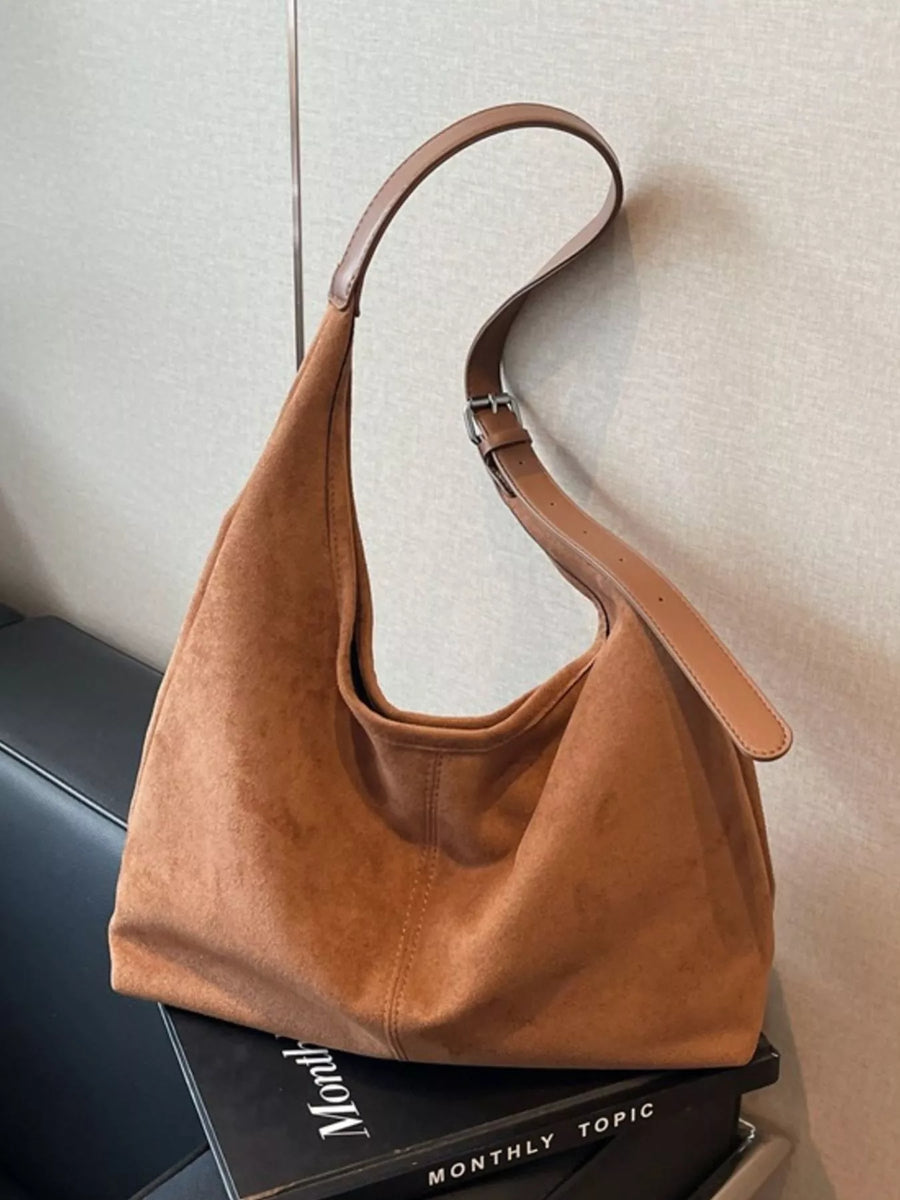 Brown suede hobo bag with adjustable strap and silver buckle detail.