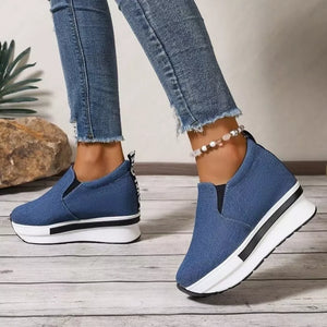Blue slip-on platform shoes with round toe and chunky white sole.