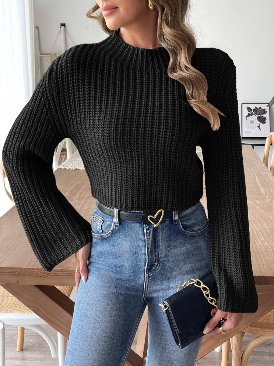 Black ribbed crop sweater with mock neck and bell sleeves.
