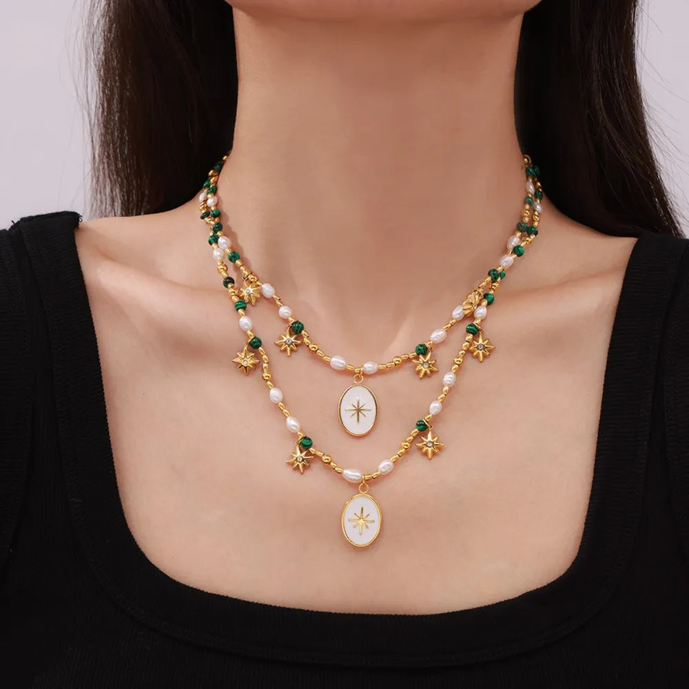 Gold celestial pearl necklace with starburst pendants and green beads