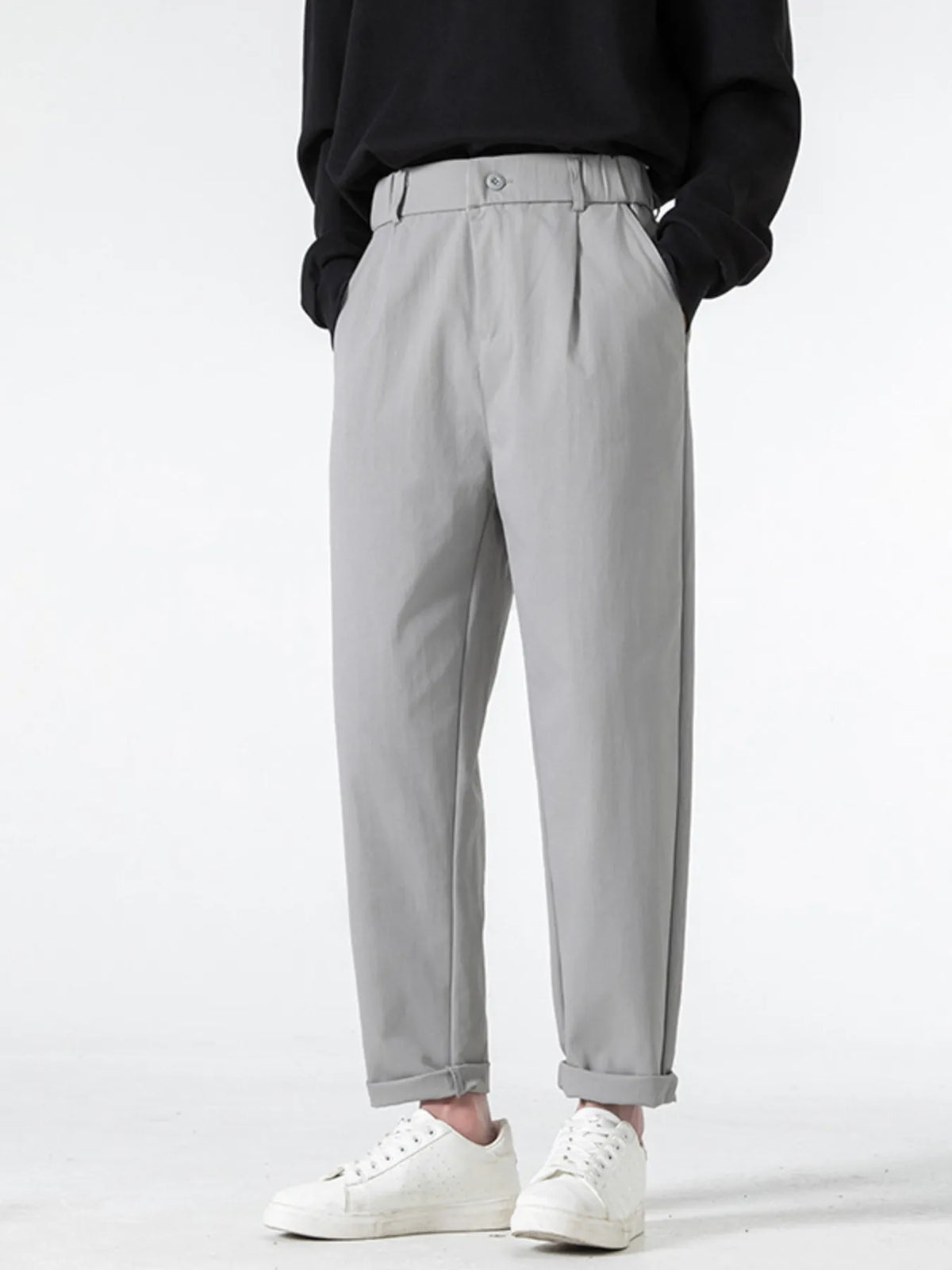 Grey casual pleated trousers with a loose fit and cuffed hems.