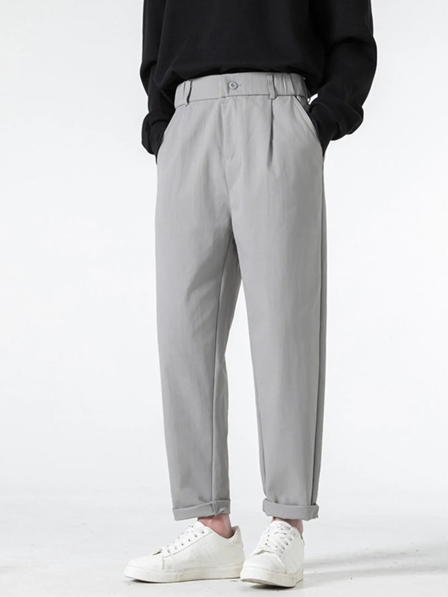 Grey casual pleated trousers with a loose fit and cuffed hems.