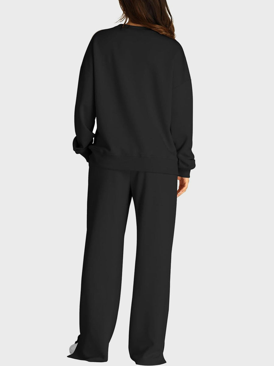 Black loungewear set with crewneck sweatshirt and wide-leg trousers with slit front detail.