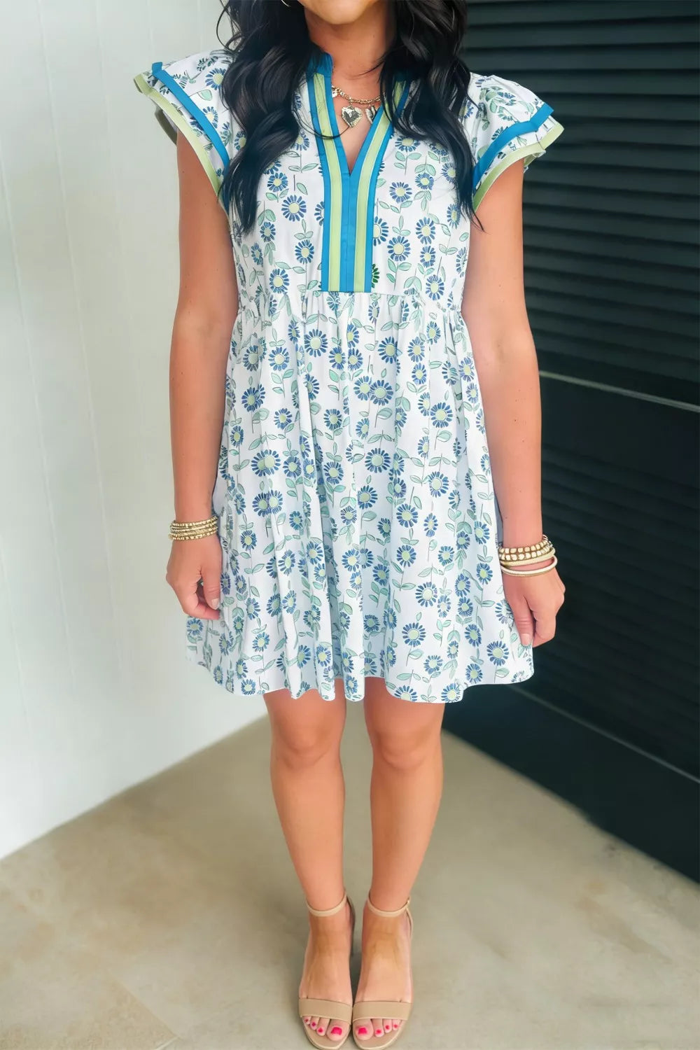 Floral cotton blend dress with notched neckline, cap sleeves, and blue floral print.