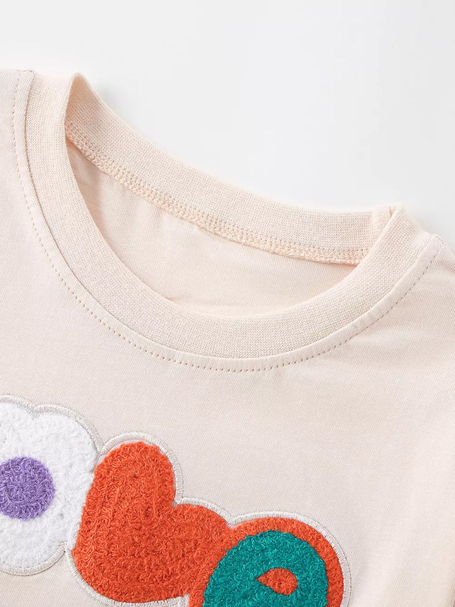 Toddler t-shirt with crew neck and playful embroidered heart and flower graphics.