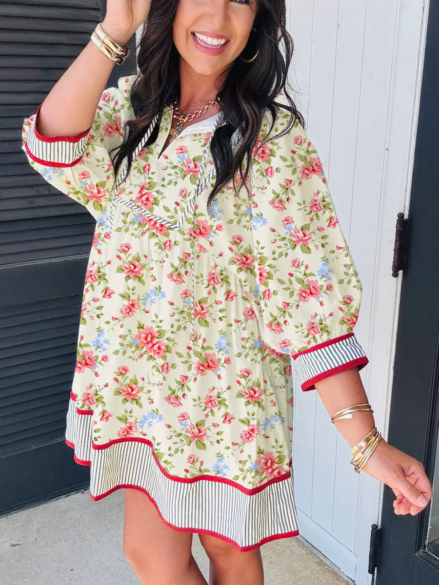 Floral puff sleeve dress with white collar, red trim, and striped hem.