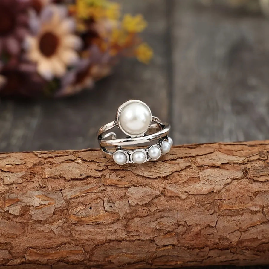 Silver ring with a large pearl and a row of smaller pearls, alloy band