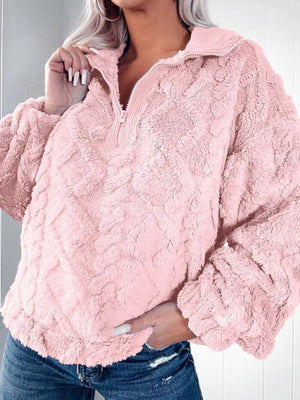 Pink textured fleece quarter zip sweatshirt with a ribbed collar and cuffs.