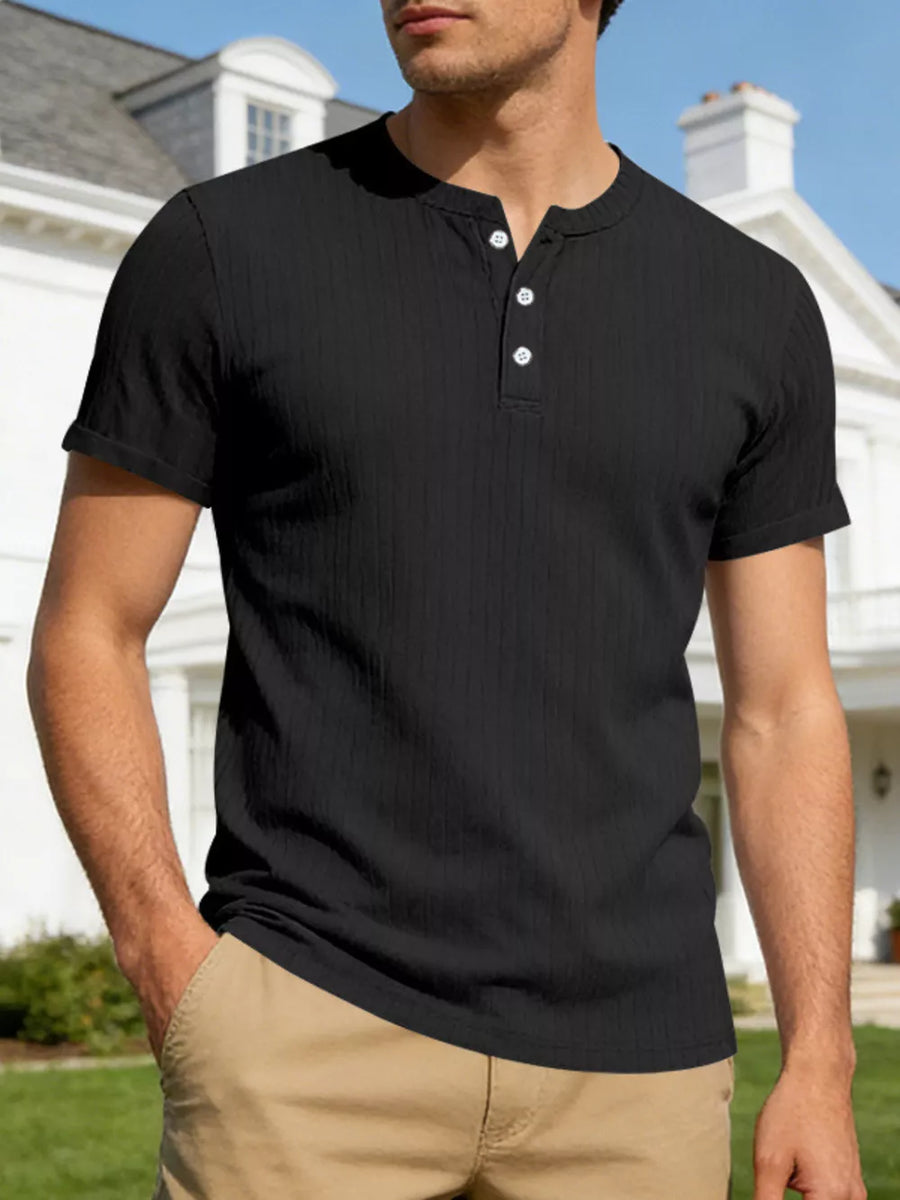 Black ribbed henley t-shirt with short sleeves and button placket, worn by a man.