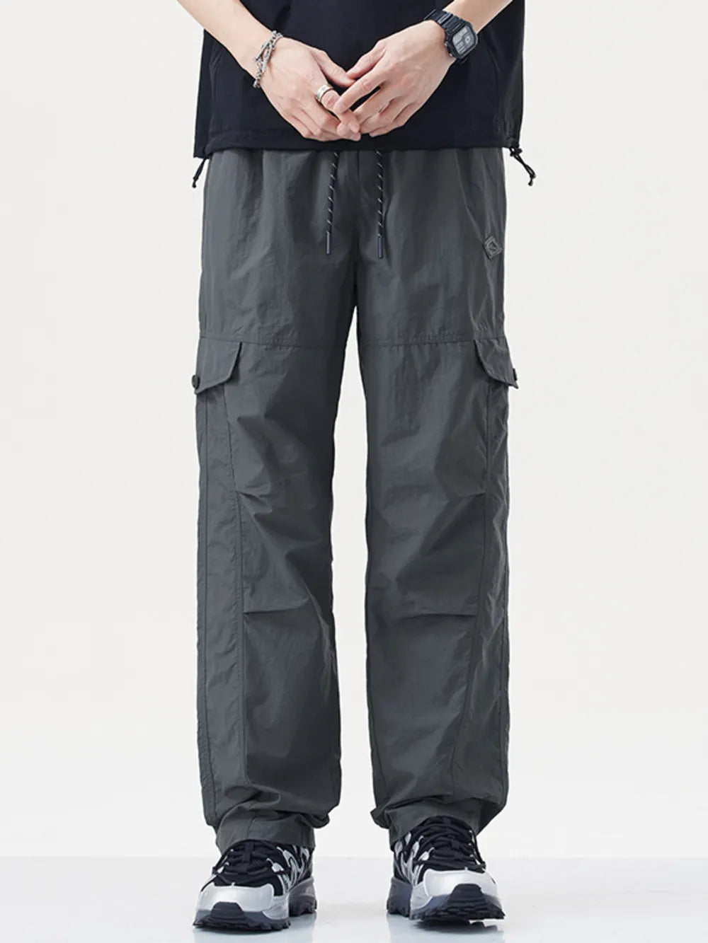 Relaxed fit gray cargo sweatpants with drawstring and button closure.