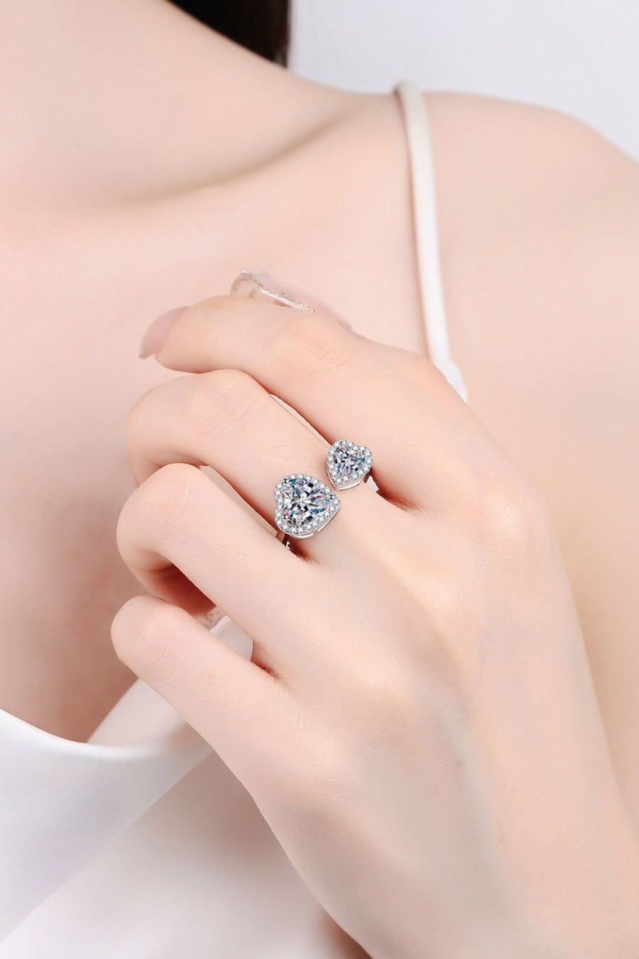 Silver double heart halo ring with clear stones on a hand
