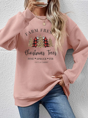 Blush pink crewneck sweatshirt with Christmas trees graphic and text.