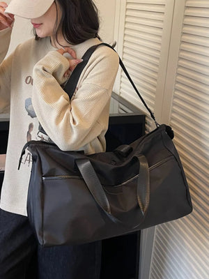 Spacious black Oxford cloth travel duffle bag with dual handles and adjustable shoulder strap.