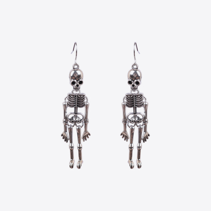 Skeleton silhouette drop earrings in silver with intricate bone detail.