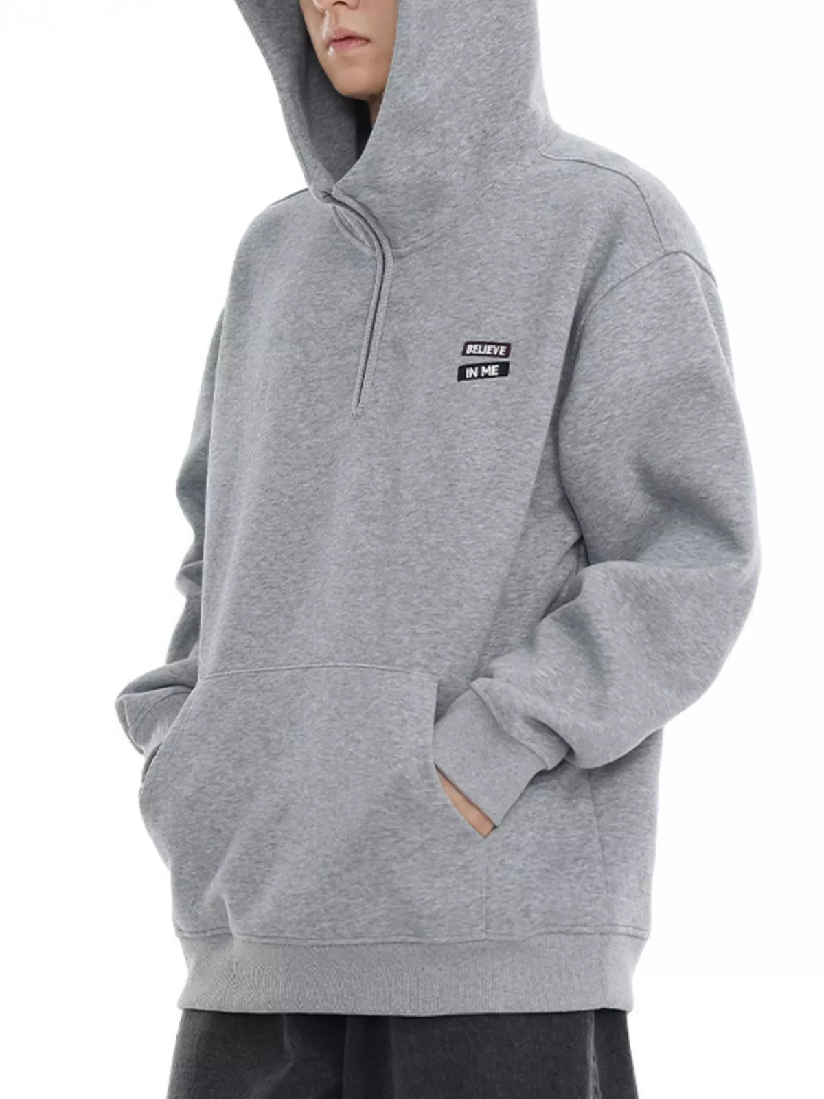 Plus-size grey quarter-zip hoodie with a small "BELIEVE IN ME" patch detail.