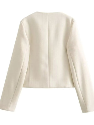 White cropped tweed button-up jacket with a round neckline and long sleeves.