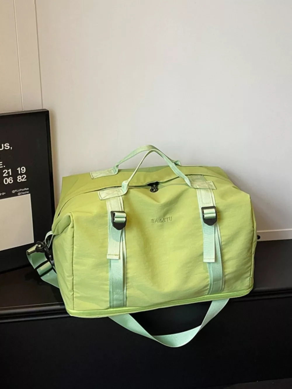 Green nylon travel bag with crinkled texture and adjustable buckle straps.