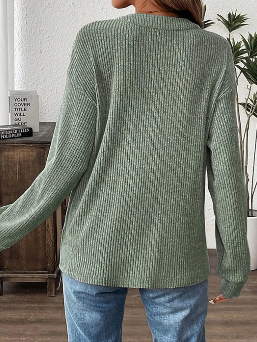 Light green ribbed long-sleeve top with button detail.
