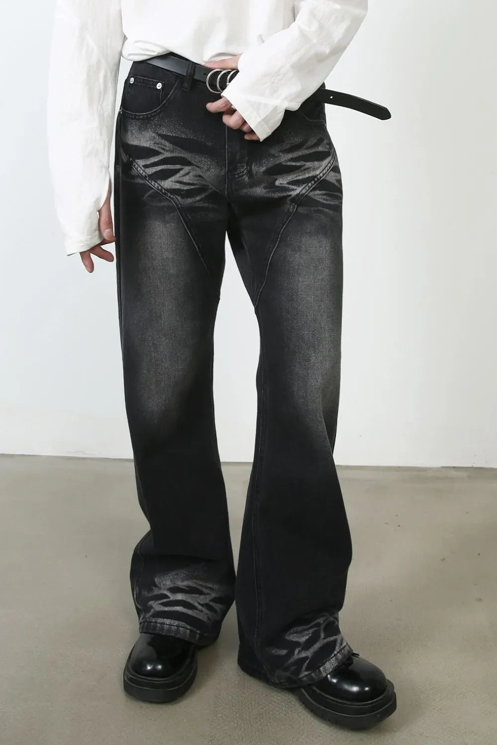 Dark distressed flare jeans with stitch detail and a faded pattern.