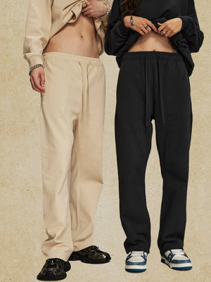 Relaxed fit lounge trousers in tan and black, featuring a drawstring waist and straight leg cut.