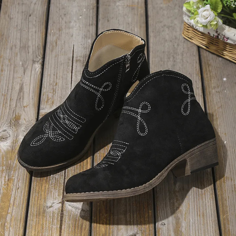 Black embroidered suede western ankle boots with side zipper and low heel.