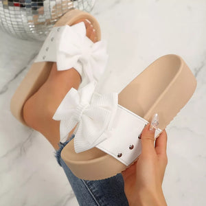 White ribbed bow accent platform sandals with studded details.