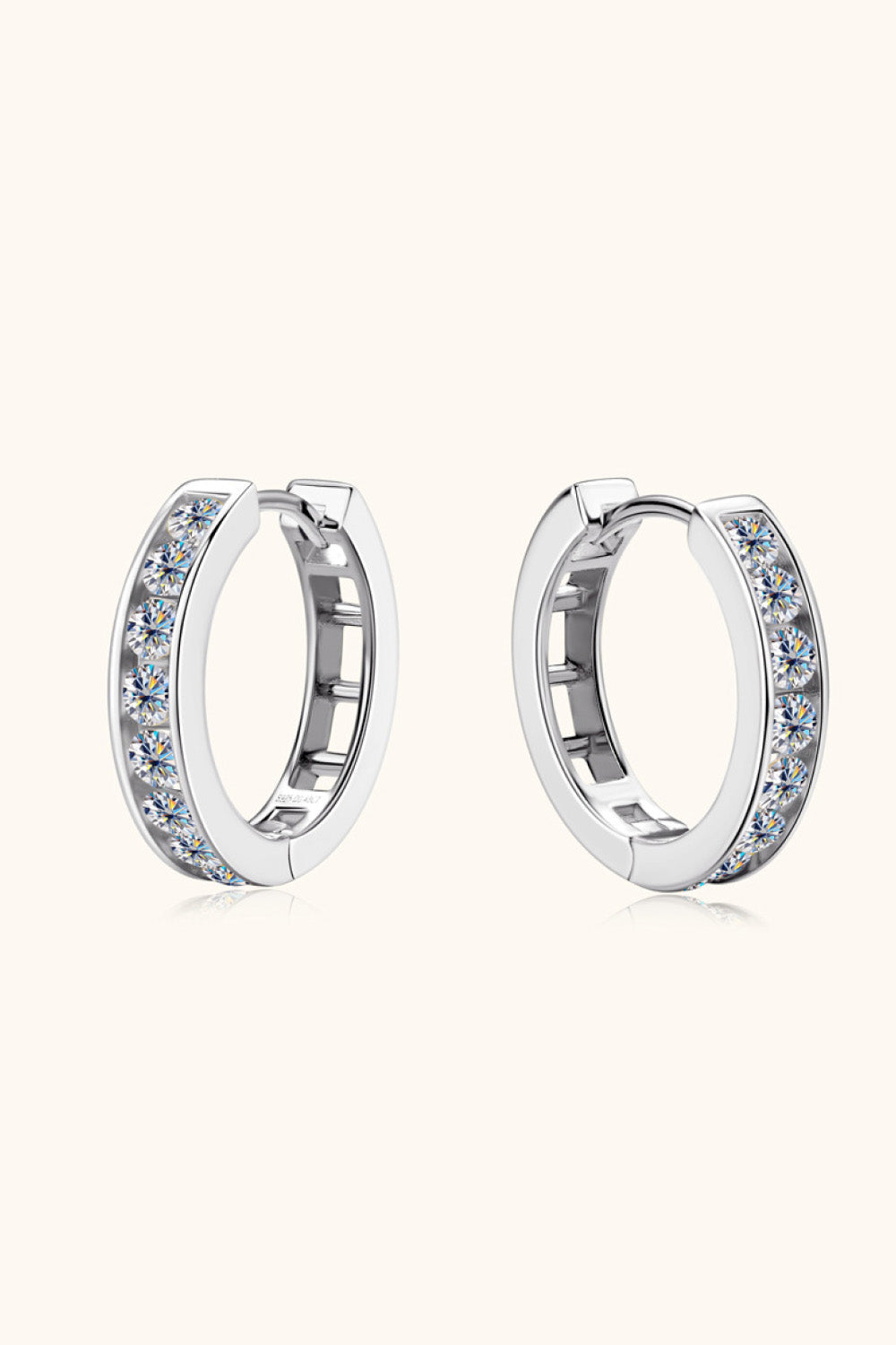 Silver moissanite channel-set hoop earrings with sparkling stones.