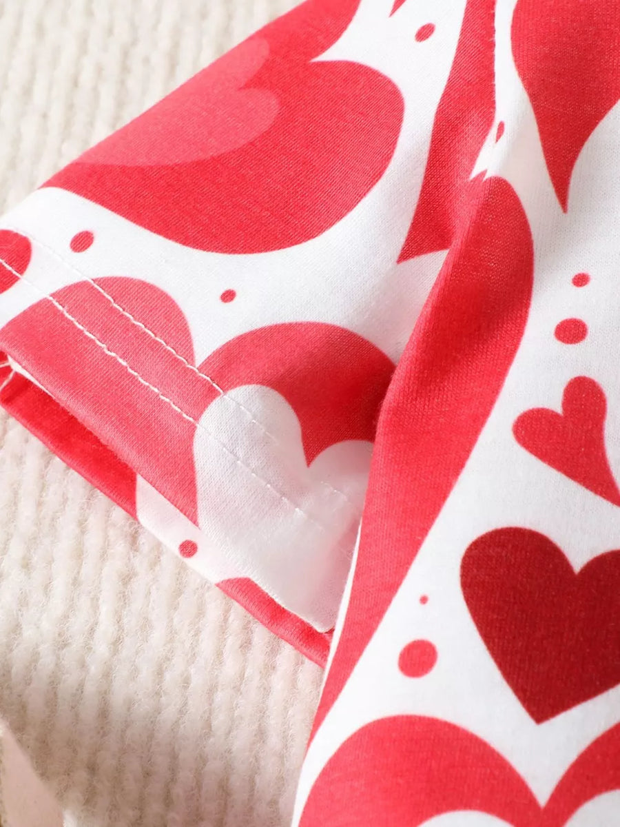 Baby polo shirt with red hearts pattern on white cotton, short sleeves.