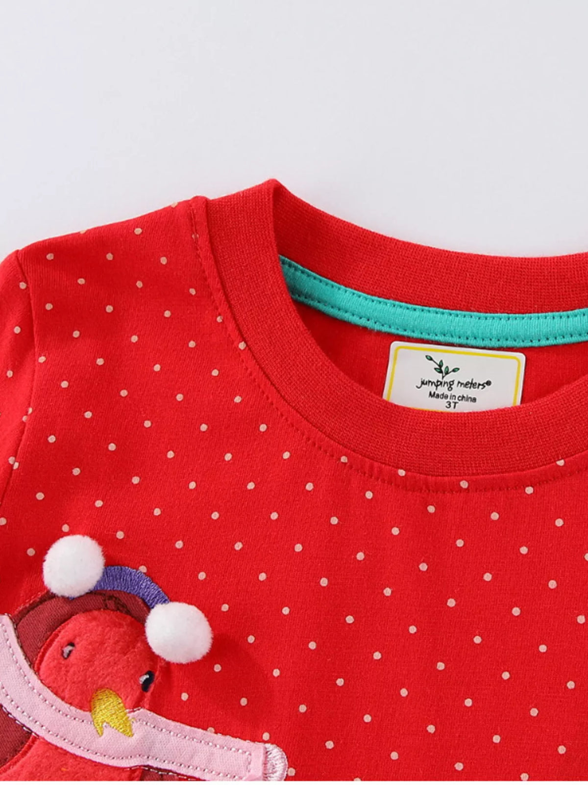Red polka dot long sleeve dress with a cute bird applique and pom-pom details.