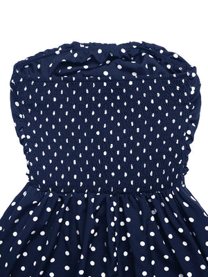 Navy polka dot strapless maxi dress with smocked bodice and ruffled neckline.