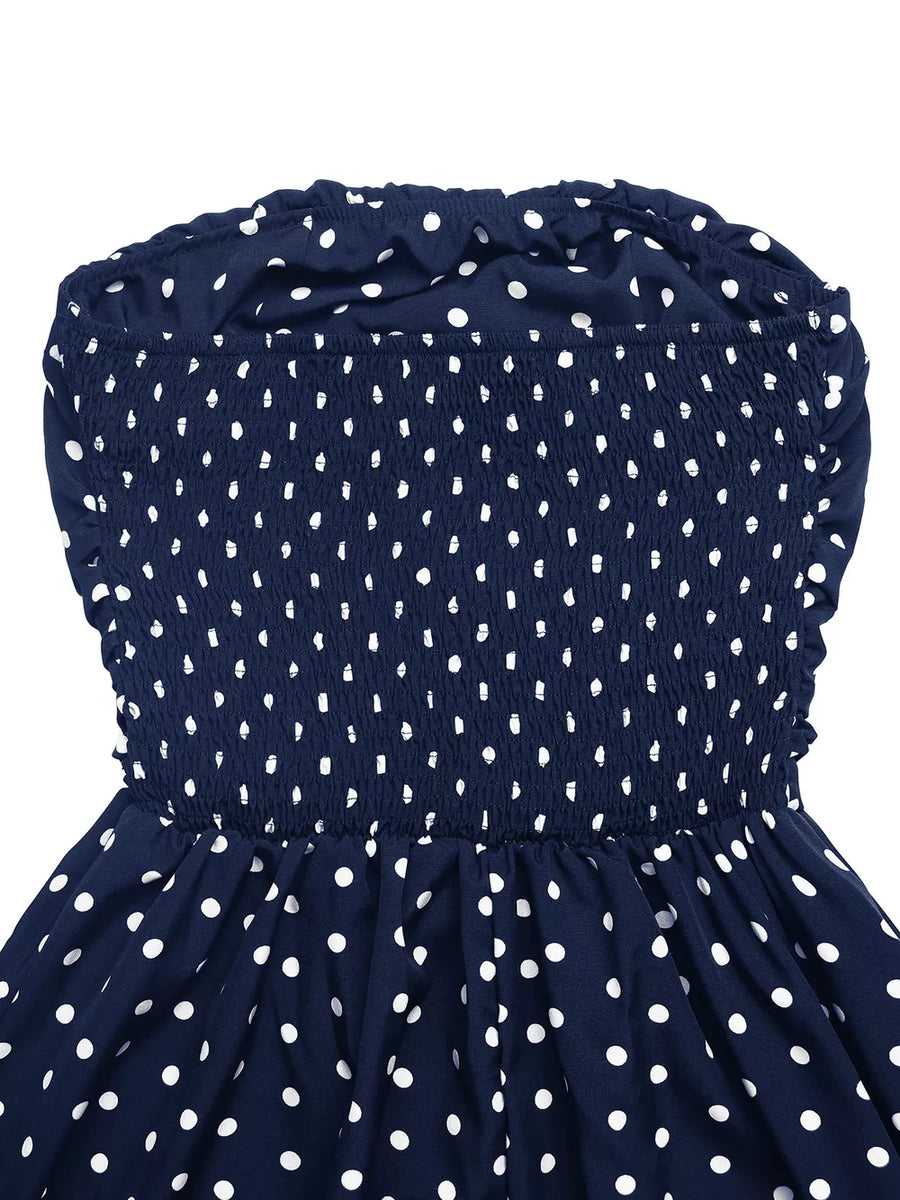 Navy polka dot strapless maxi dress with smocked bodice and ruffled neckline.