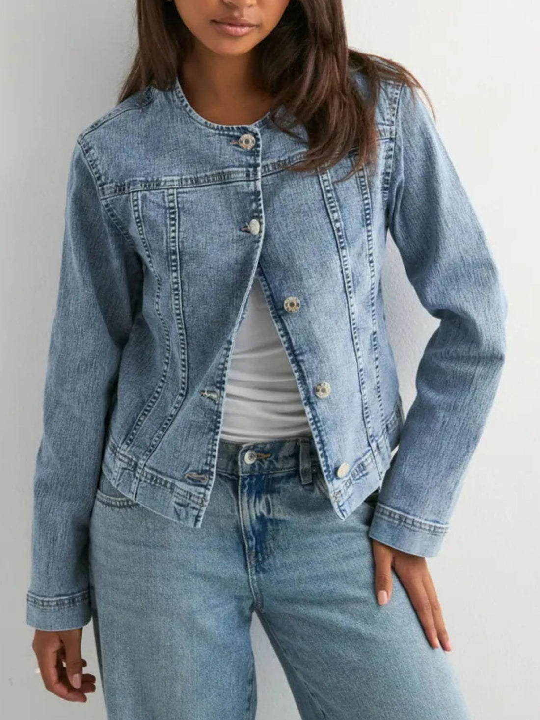 Button-down denim jacket with seam detailing and collarless neckline.