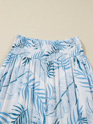 Tropical leaf print wide leg pants with smocked waistband and blue and white pattern.