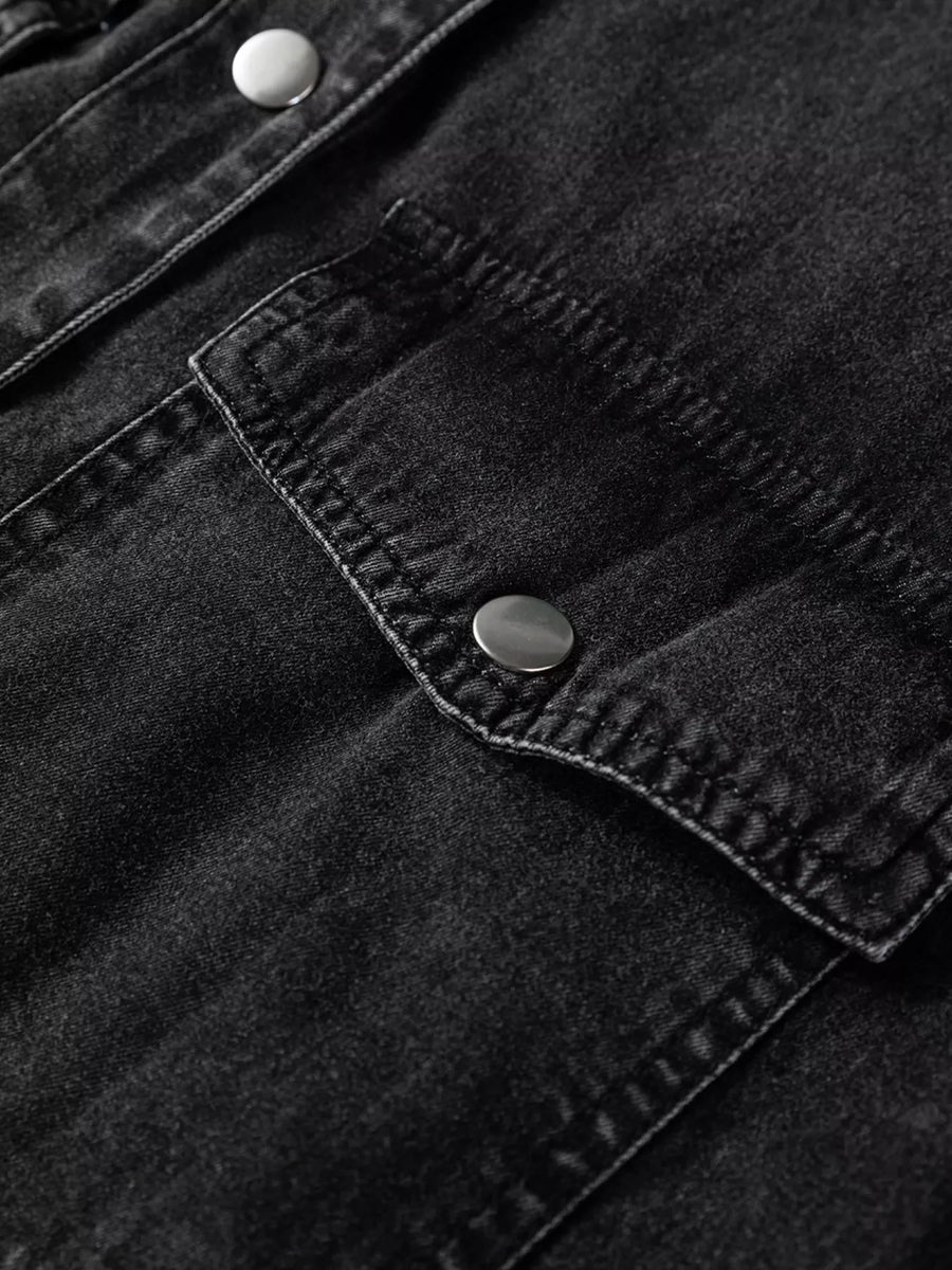 Black denim button-up dress with snap button chest pockets and raw hem detail.