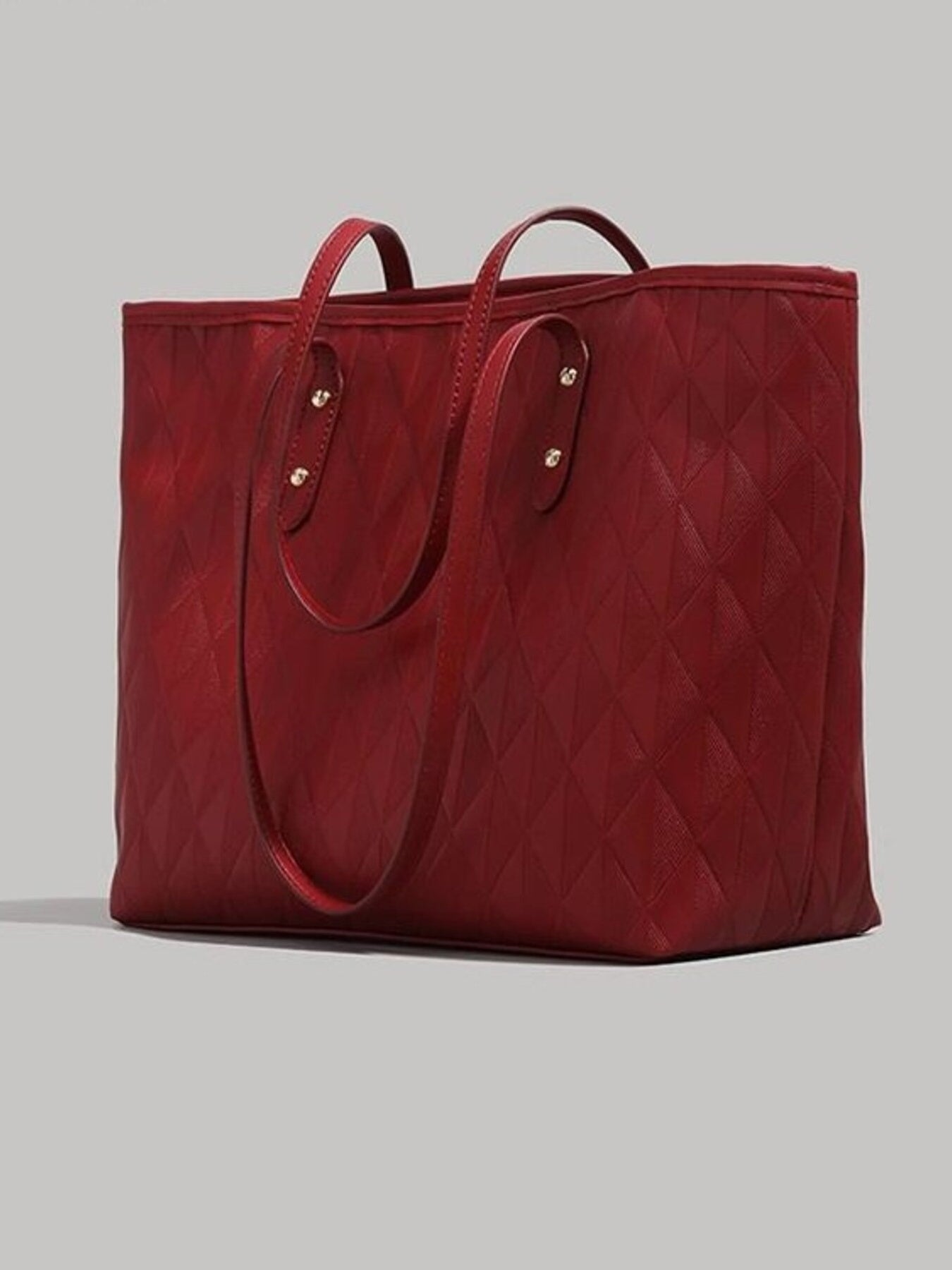 Red quilted pu leather tote bag with diamond pattern and double handles.