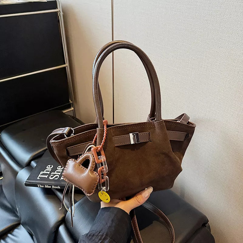 Elegant suede and leather mini tote in coffee brown with charm details.