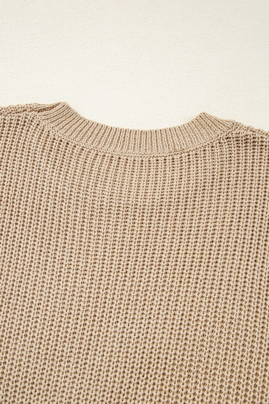 Tan acrylic knit tank top with crew neck and textured stitch detail.